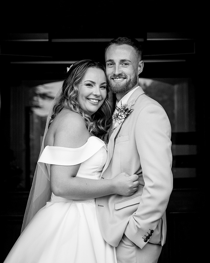 Bride and groom laughing together inside Tankersley Manor due to rain.