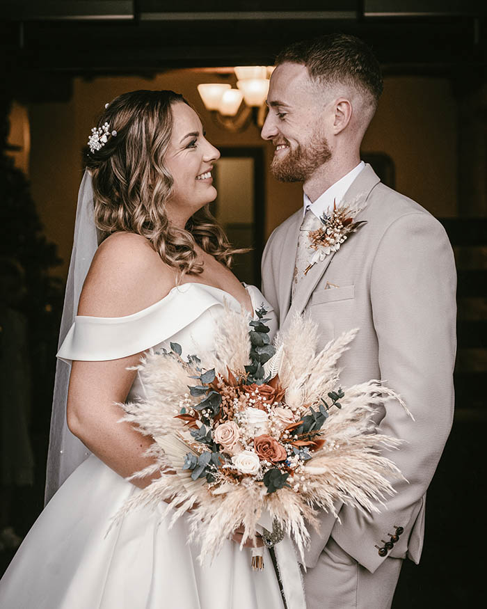 Bride and groom laughing together inside Tankersley Manor due to rain.