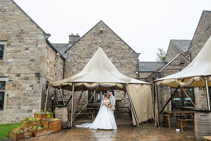 Bride and groom together under the tipi at Tankersley Manor due to rain.