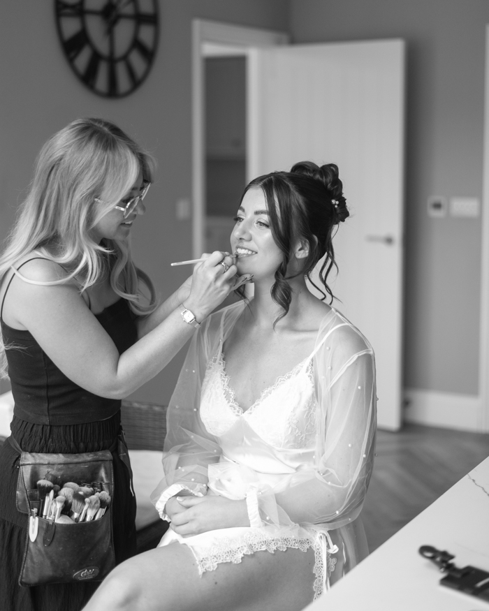 Bride having her makeup done during morning preparations at Inkersall Grange Farm