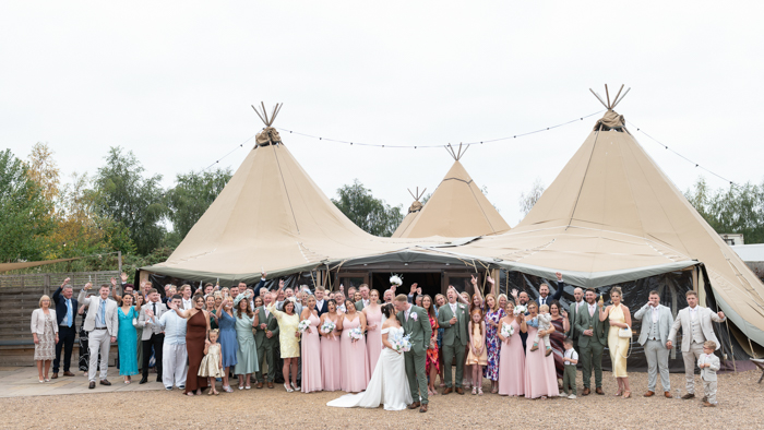 Full wedding party group photo in the outdoor ceremony space