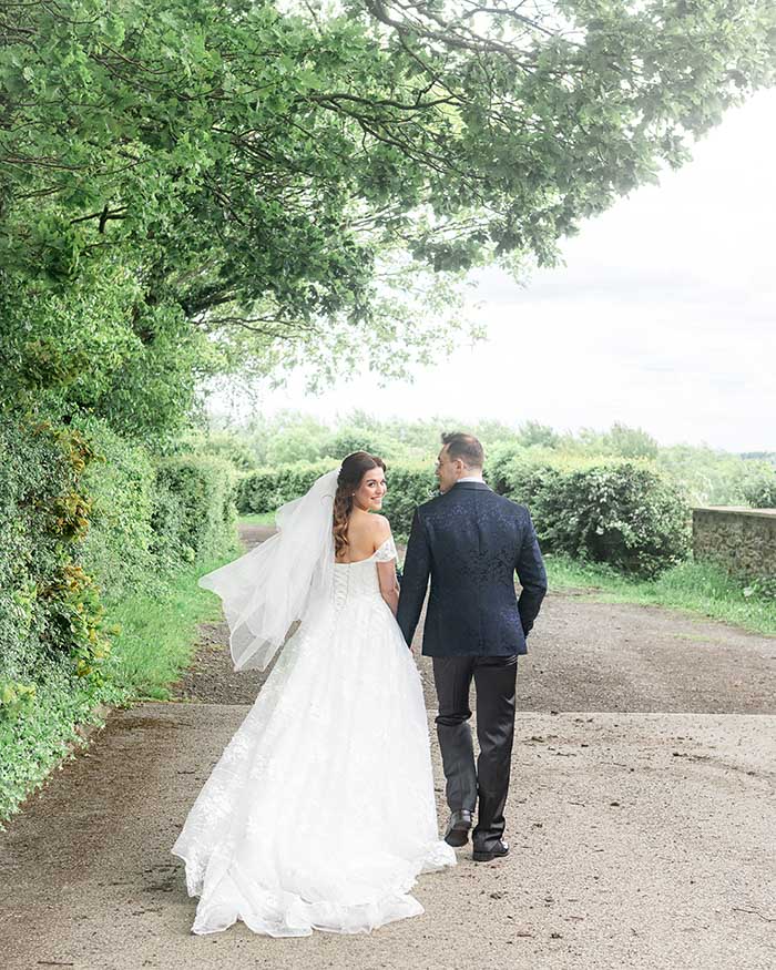 Relaxed bride and groom portraits by the stone walls and greenery