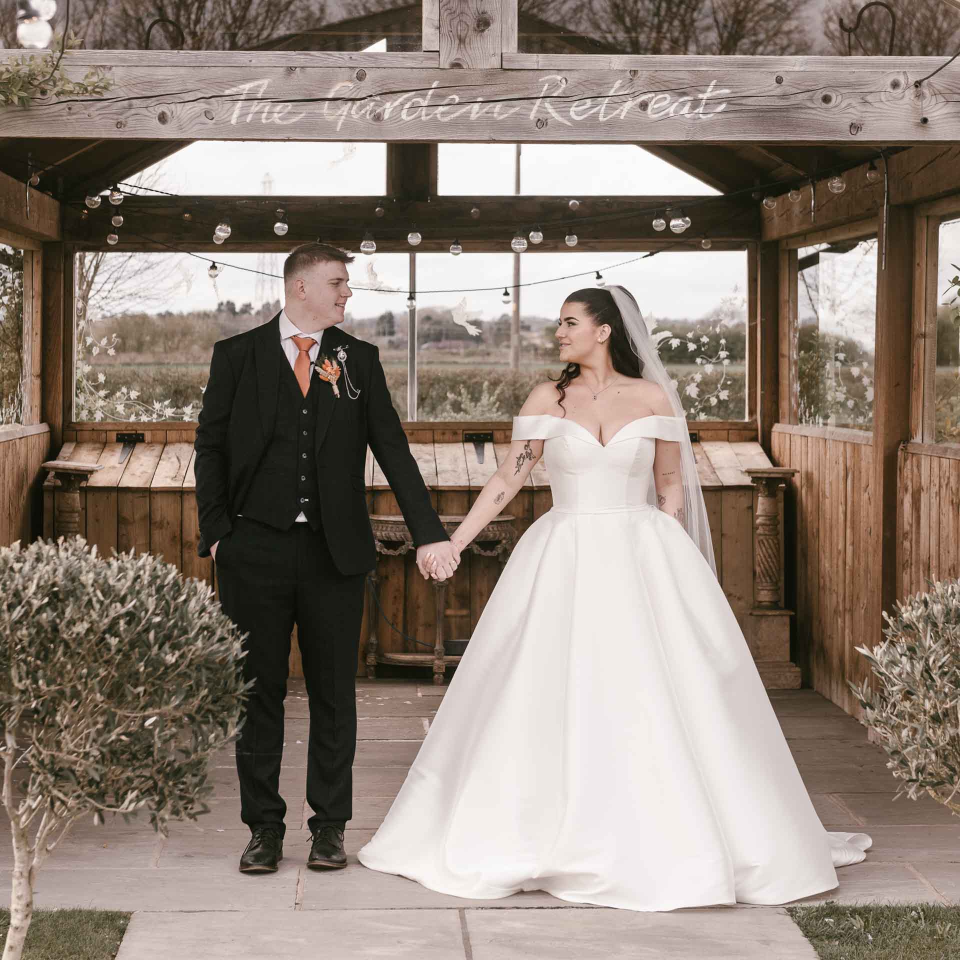 bride and groom under a wooden structure at beverley barn