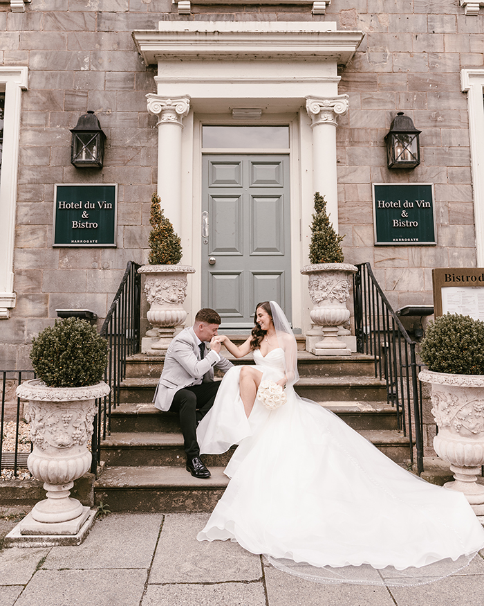 bride and groom sitting on the steps at hotel dun vin harrogate
