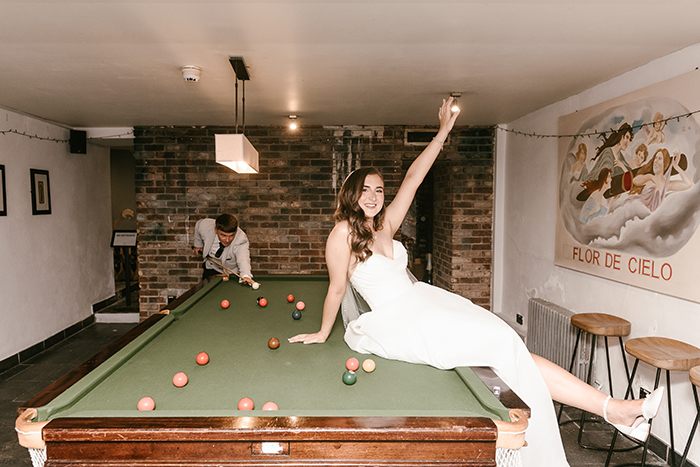 bride sitting on the snooker table at hotel du vin harrogate