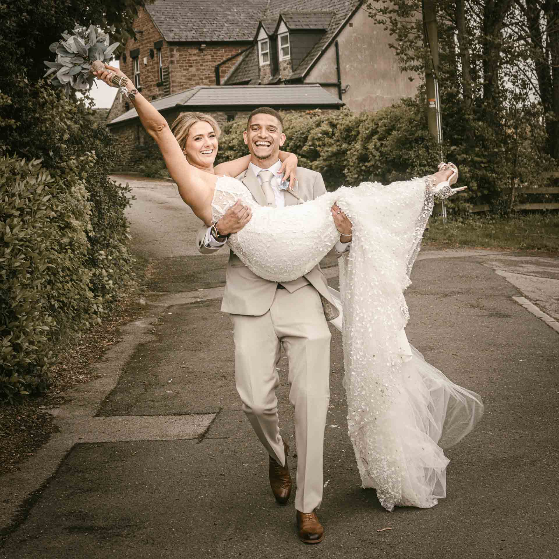 groom carrying a bride on their wedding day