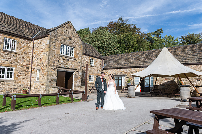 bride and groom stood outside the crook barn at tankersley manor